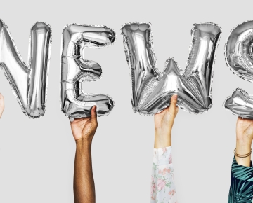 News Balloons Held Up By People