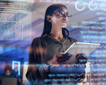 woman holding tablet and looking at screen with data