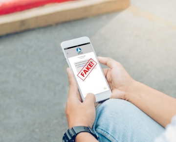 person looking at phone that says fake