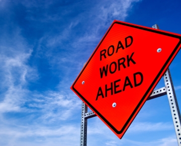 road work ahead sign against blue sky