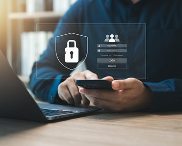 man in dark blue shirt using laptop and phone with virtual password screen floating